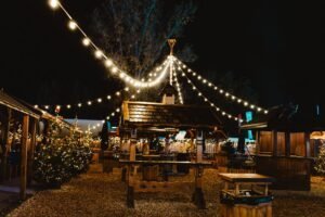 Mulțime cu mâinile ridicate în fața unei scene luminate, seara, la un festival